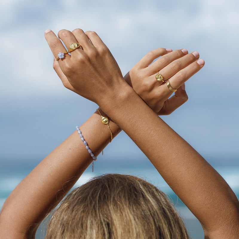 Damen Gold Ring mit blauer Blume auf der Vorderseite  | PRODUCT: float-seepferdchen-ring-gold_30_75  | PRODUCT: float-korallen-pearl-ring-gold_65_65  | PRODUCT: float-korallen-armband-gold_35_35 | PRODUCT: float-atlantik-ring-gold_70_60