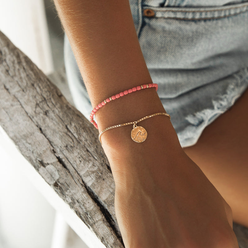 Damen Gold Armband mit Wellen Anhänger und rotes Perlen Armband. | Style: Hanalei